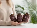 Person håller tre burkar magnesiumtillskott. Kan hjälpa mot bland annat magnesium illamående.