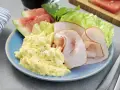 En blå tallrik med äggröra, kalkonpålägg, vattenmelon och sallad. En perfekt 5:2 frukost för en hälsosam start.