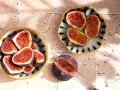 Färska fikon, halverade och upplagda i skålar, visar sitt saftiga, röda inre. Torkade fikon nyttigt som en hälsosam snack.