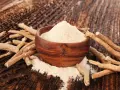 Ashwagandha-pulver i en träskål omgivet av rötter. Ett naturligt stöd för kvinnor under klimakteriet.