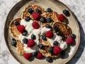 Proteinpannkakor recept: fluffiga pannkakor toppade med grädde, hallon och blåbär. En perfekt start på dagen!