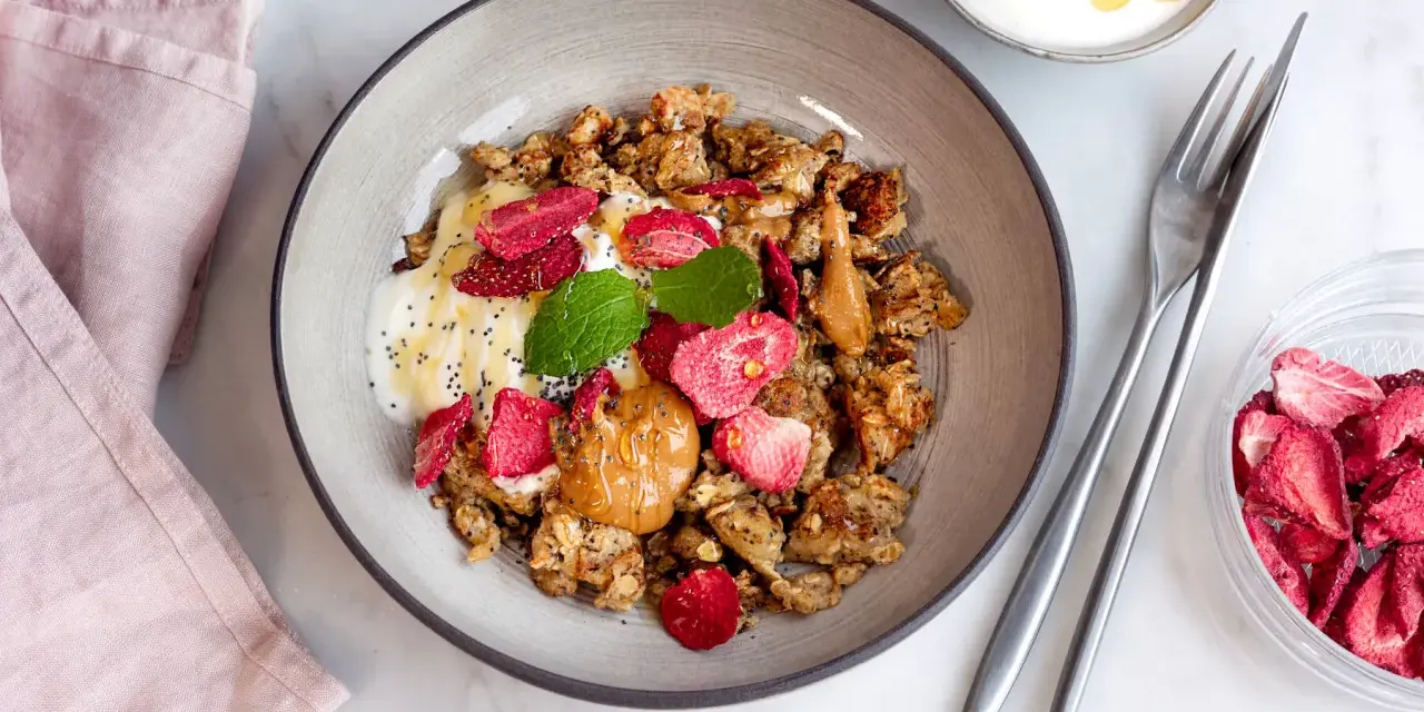 En skål med granola, yoghurt, jordgubbar och jordnötssmör. En perfekt nyttig frukost för en bra start på dagen.