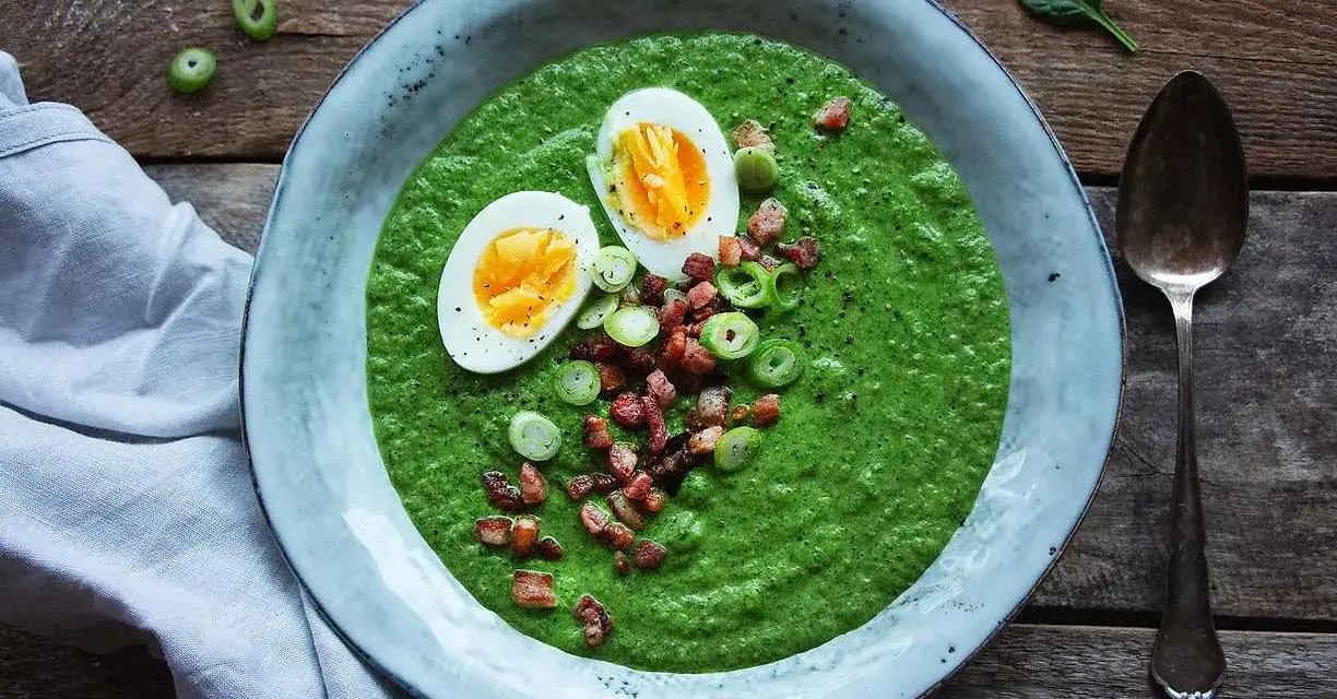 En krämig spenat och broccolisoppa toppad med ägg, knaperstekt bacon och salladslök. En härlig och näringsrik måltid.