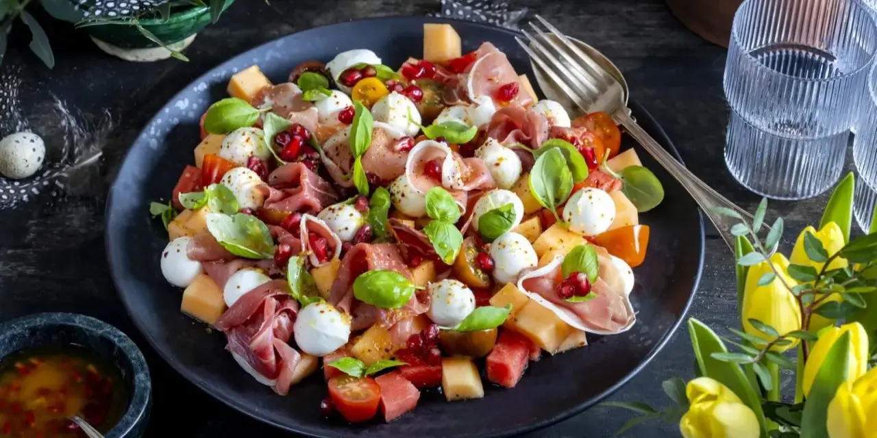 En läcker melonsallad med mozzarella, prosciutto, granatäpple och färsk basilika. En perfekt sommarrätt!