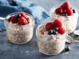 Tre burkar med overnight oats recept, toppade med hallon och blåbär. En perfekt frukost att förbereda kvällen innan.