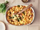 En krämig pastarätt med spenat och lax, perfekt för nyttiga recept. En träsked lyfter upp en portion ur ugnsformen.