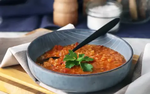 En värmande linssoppa, perfekt för dig som vill gå ner i vikt. Serveras i en blå skål med en persiljekvist.