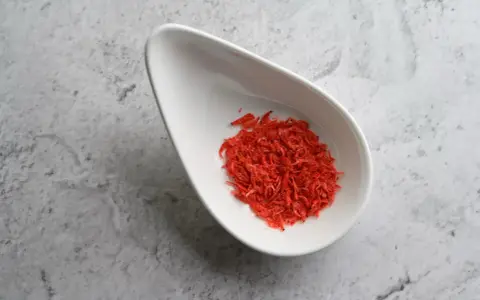 Torkade räkor i en vit skål, en källa till astaxanthin. Undrar du över astaxanthin biverkningar?