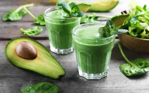 Två gröna smoothies med mynta och avokado. Ingredienser som spenat, som är rik på lutein, finns i.