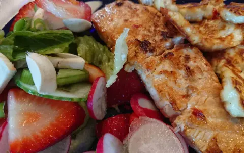 En härlig sallad med grillad lax, halloumi, jordgubbar, rädisor och grönsaker. En perfekt sommarmåltid!