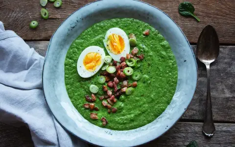 En krämig spenat och broccolisoppa toppad med ägg, knaperstekt bacon och salladslök. En härlig och näringsrik måltid.