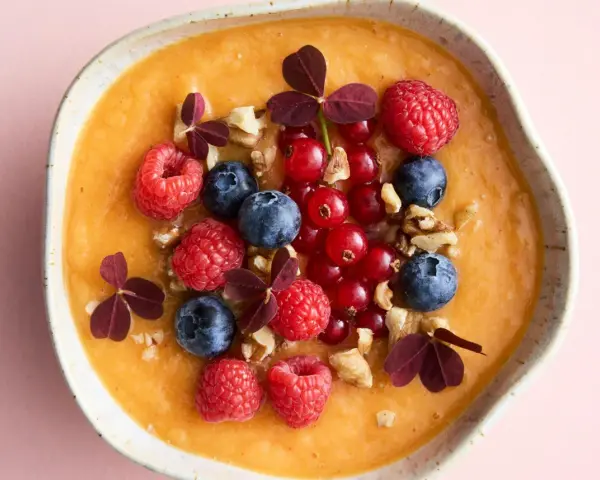 En krämig smoothiebowl med hallon, blåbär, vinbär och valnötter. En perfekt antiinflammatorisk kost frukost för en energifylld start på dagen.