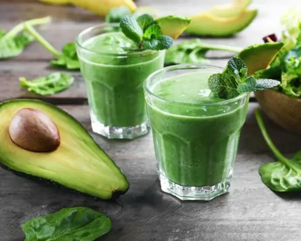 Två gröna smoothies med mynta och avokado. Ingredienser som spenat, som är rik på lutein, finns i.