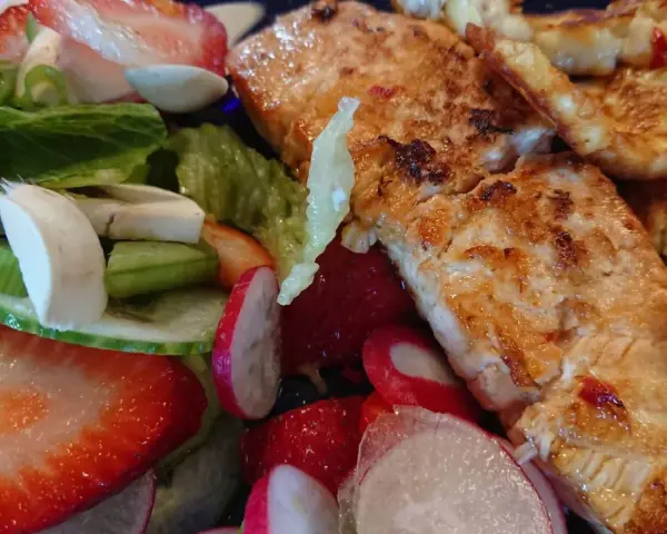 En härlig sallad med grillad lax, halloumi, jordgubbar, rädisor och grönsaker. En perfekt sommarmåltid!