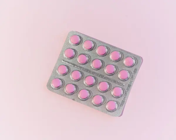 En blisterförpackning med rosa tabletter, en lösning för att få bort herpes i underlivet snabbt.