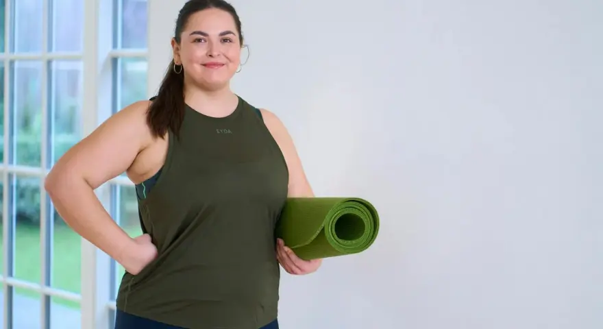 En kvinna med träningskläder och en grön yogamatta redo att kickstarta viktnedgång.