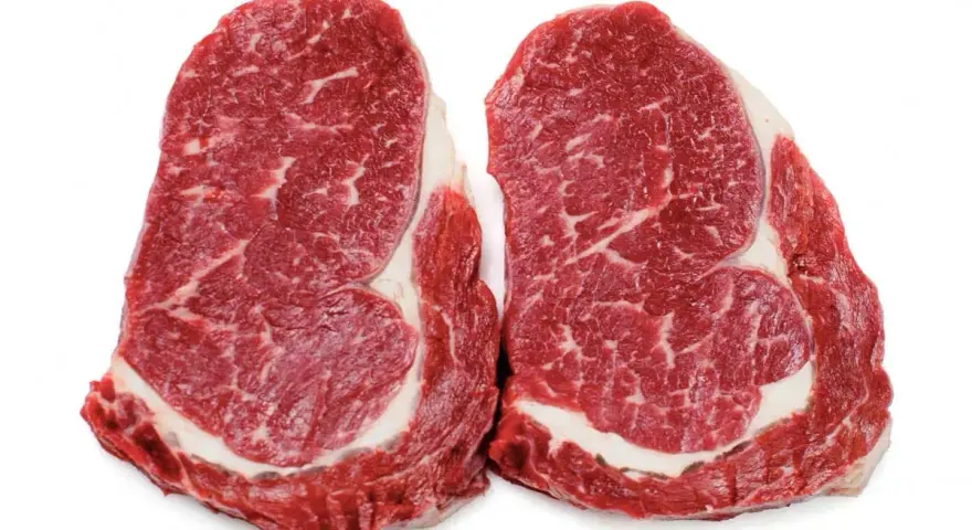 Två råa entrecôte-biffar med fin marmorering, perfekta för en gravid som längtar efter en saftig måltid.