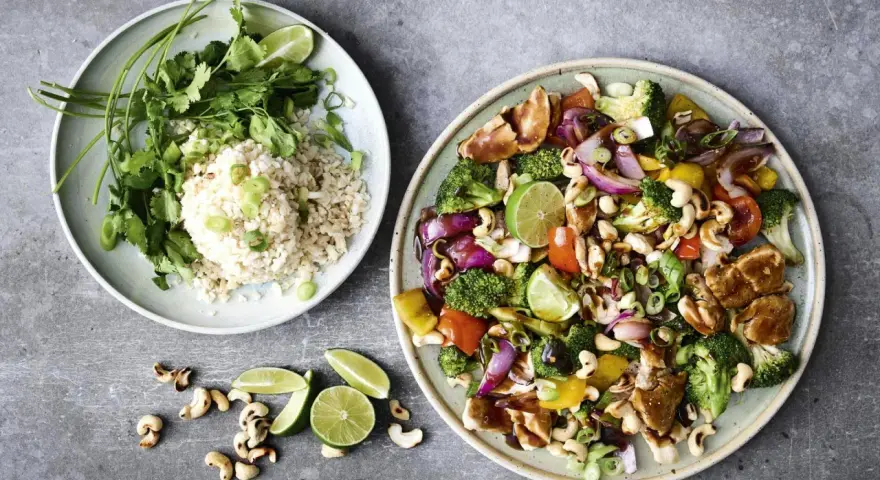En färgstark wok med kyckling, grönsaker och cashewnötter, serverad med ris och lime. Perfekt för en snabb middag på 30 minuter.