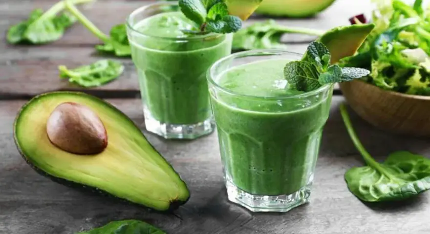 Två gröna smoothies med mynta och avokado. Ingredienser som spenat, som är rik på lutein, finns i.