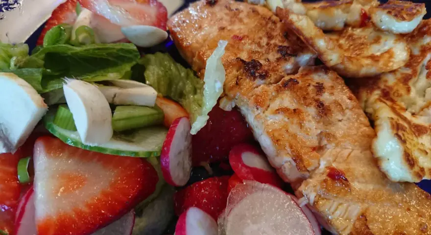 En härlig sallad med grillad lax, halloumi, jordgubbar, rädisor och grönsaker. En perfekt sommarmåltid!