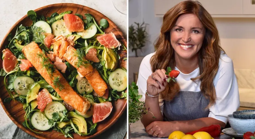 En kvinna med jordgubbe i handen och en fräsch lax- och avokadosallad. Recept för att gå ner 2 kg i veckan.