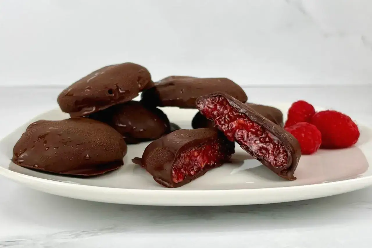 Chokladdoppade hallon, en h&auml;rlig sockerfri dessert. En bit visar den saftiga insidan.
