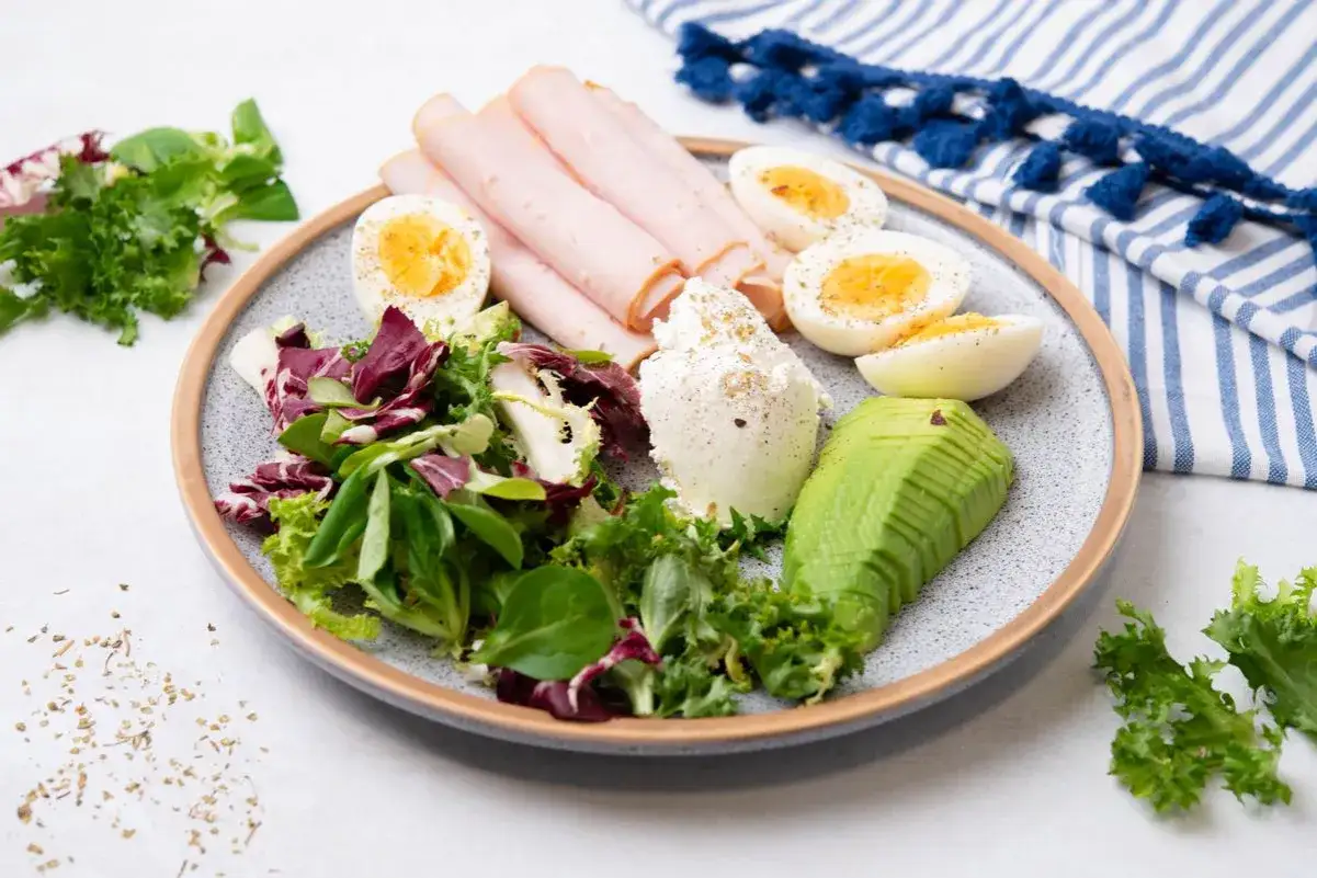 En tallrik med &auml;gg, kalkonp&aring;l&auml;gg, avokado, f&auml;rsk sallad och f&auml;rskost. Perfekt f&ouml;r keto viktnedg&aring;ng.