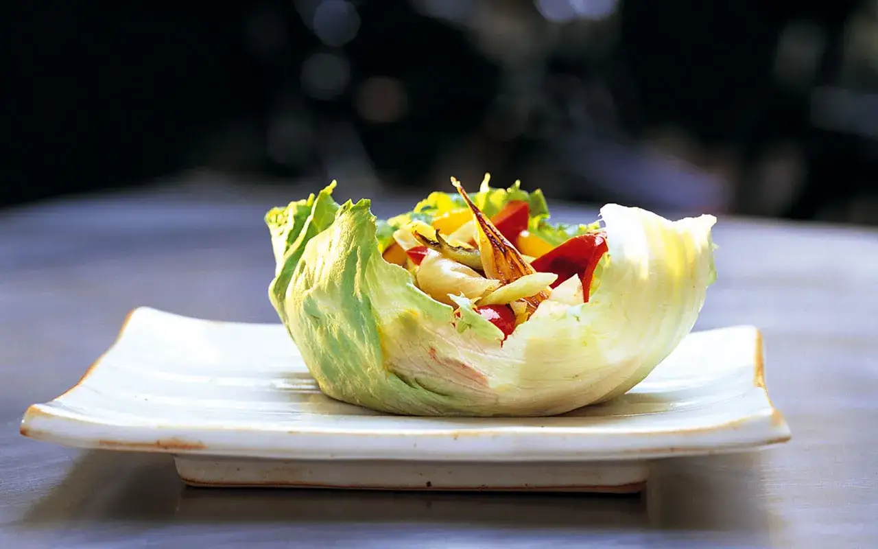 En fr&auml;sch sallad i ett krispigt isbergssalladsblad, fylld med gr&ouml;nsaker. Ett bevis p&aring; att isbergssallad nyttigt kan vara.