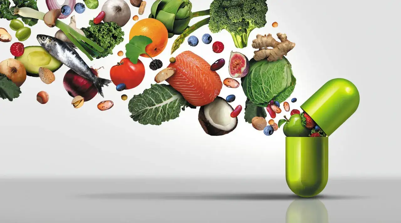Frukt, grönsaker, fisk och nötter svävar mot en stor grön kapsel, som en visuell representation av vitaminer fakta.