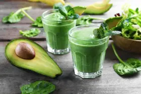 Två gröna smoothies med mynta och avokado. Ingredienser som spenat, som är rik på lutein, finns i.